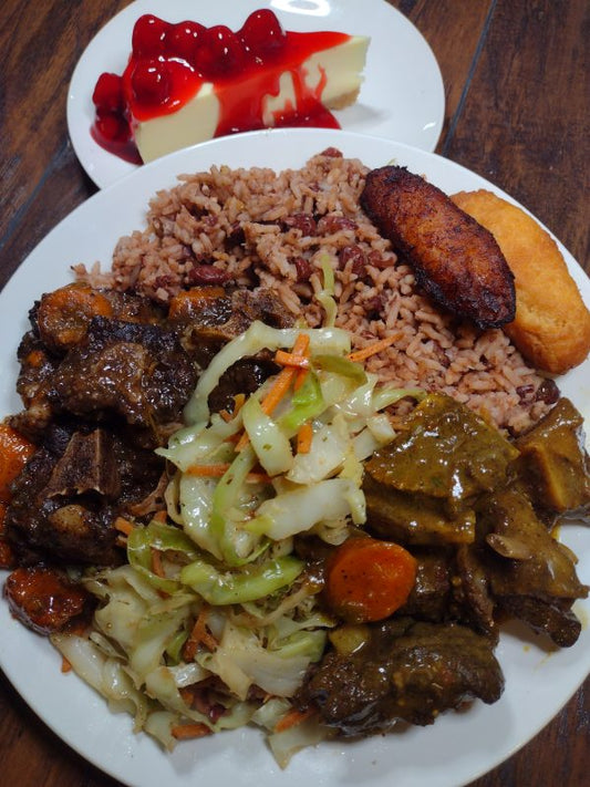 Billy Ox - Ox Tails, & Curry Goat + Slice of Cheesecake- Braised Ox Tails and Curry Goat are served with rice &amp; peas, stewed cabbage, festival, and sweet plantains. And don't forget the cherry topped Cheesecake for a sweet finish.