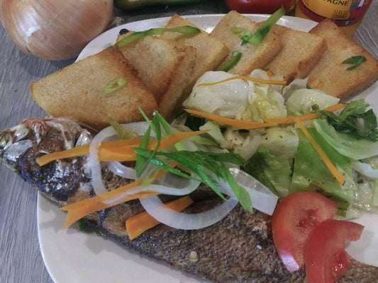 2 Escovitch Fried Fish Served With Banmmy (Feeds 2)- accompanied by our delicious Banmmy. Perfect for 2 people, it's a traditional dish that offers a tangy, crispy texture and a burst of Jamaican flavors. Experience a taste of the islands with every bite.