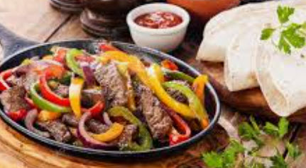 Wicked Steak Fajitas! Tender, juicy steak, seasoned and grilled to perfection. Served with sauteed onions and peppers, guacamole, sour cream, cheese, pico de gallo, rice, and beans for a tasty and satisfying meal.